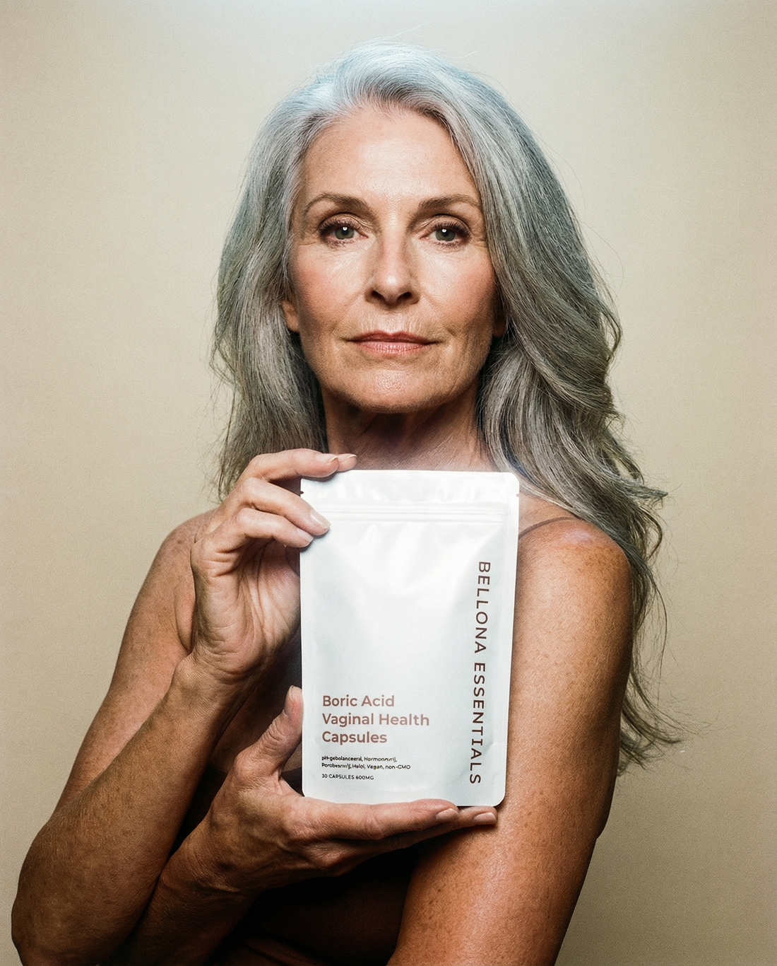 Oudere vrouw met grijs haar houdt Bellona Essentials boorzuur capsules verpakking vast, complete intieme verzorgingsroutine